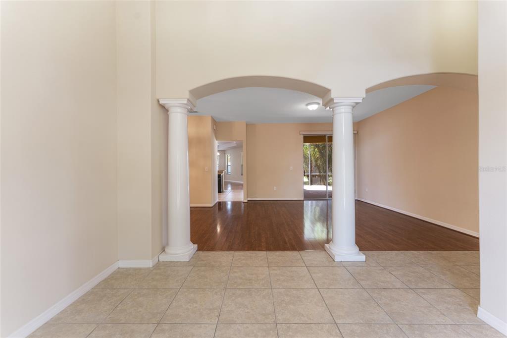 A tiled entryway leads to a living area with two white columns and wood flooring — 2637 YUKON CLIFF DRIVE, RUSKIN, FL