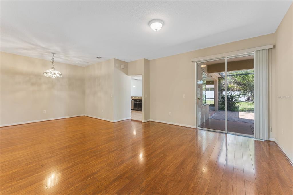 An empty dining area with hardwood floors, a hanging light fixture, and sliding glass doors — 2637 YUKON CLIFF DRIVE, RUSKIN, FL