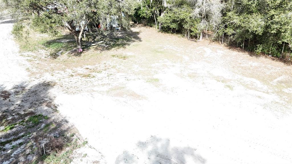 An aerial view shows a sandy, partially cleared lot with scattered trees and surrounding woods — 12510 ROBINHOOD ROAD, HUDSON, FL