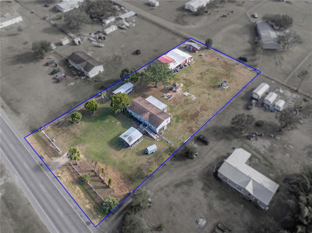 An aerial view shows a house and several outbuildings on a fenced rectangular lot — 11404 LITHIA PINECREST ROAD, LITHIA, FL