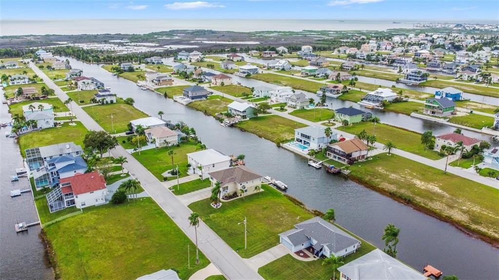 An aerial view shows houses along a canal in a residential waterfront neighborhood — 4009 CROAKER DRIVE, HERNANDO BEACH, FL