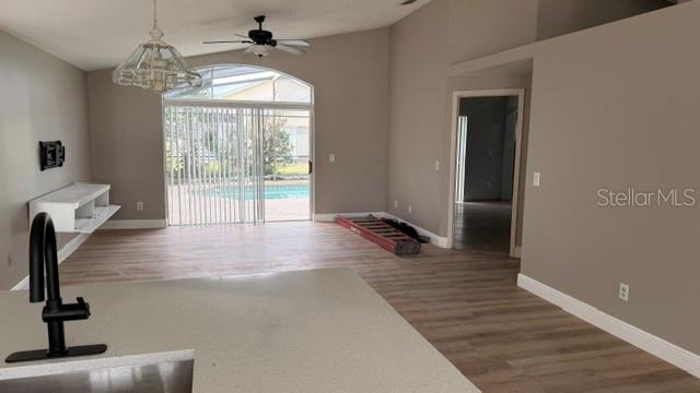 An open-concept living area features light wood-look flooring, a ceiling fan, and a sliding glass door — 1619 ELMSTEAD COURT, ORLANDO, FL