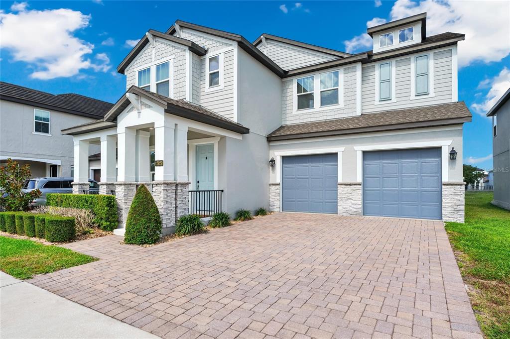 A two-story suburban house with a paved driveway, two-car garage, and light-colored siding — 12929 WESTSIDE VILLAGE LOOP, WINDERMERE, FL