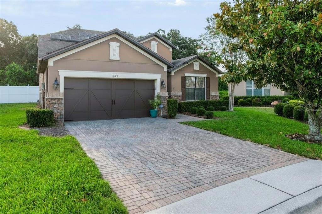 A single-story house with a paved driveway, a two-car garage, and a tan stucco exterior — 442 DEL SOL AVE, DAVENPORT, FL