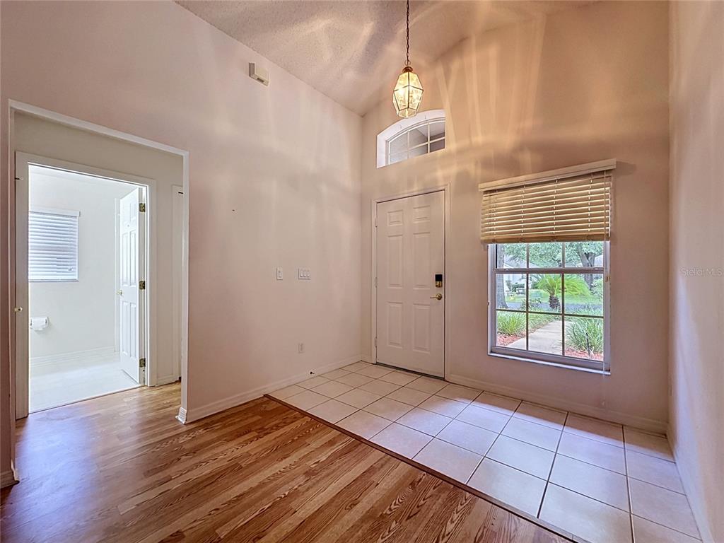 An entryway features tile flooring, a front door with a transom window, and wood flooring — 3675 EVERSHOLT STREET, CLERMONT, FL