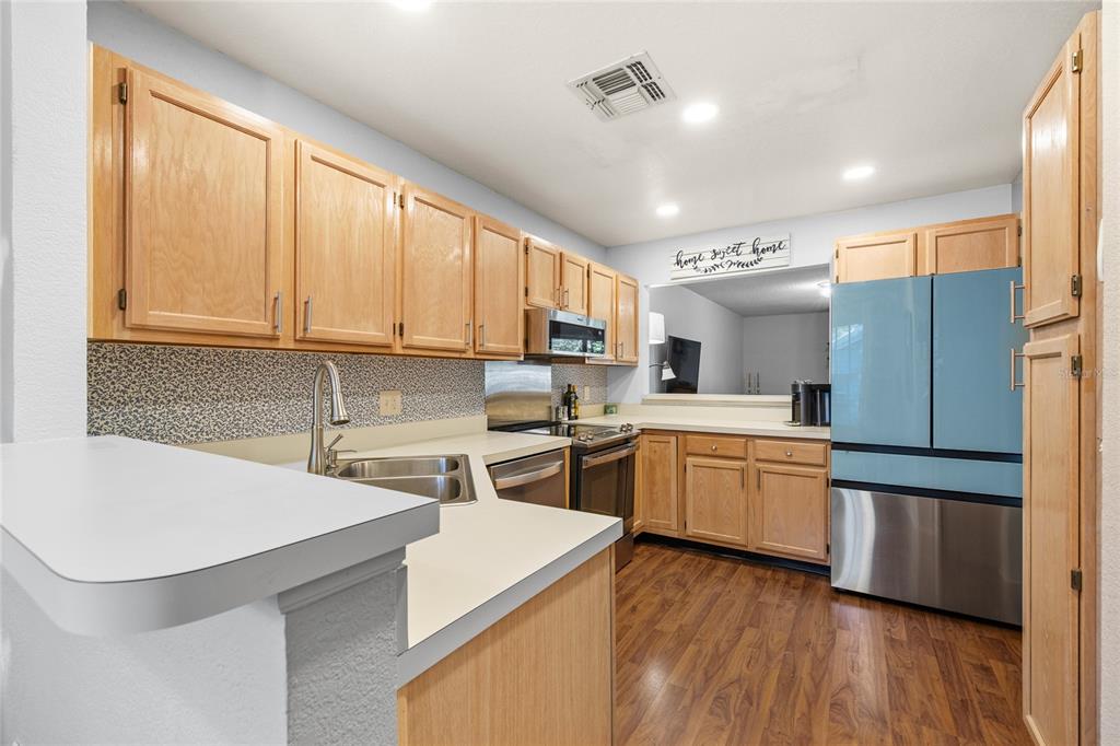A kitchen features light wood cabinets, a blue refrigerator, and a white countertop — 1482 CREEKSIDE CIRCLE, WINTER SPRINGS, FL