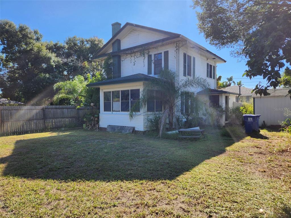 A two-story white house with a screened-in front porch stands in a grassy yard — 4815 3RD AVENUE N, ST PETERSBURG, FL