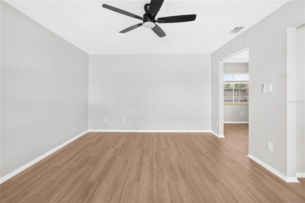 A kitchen with white cabinets, a quartz island, and light wood-look flooring — 1442 CANTERBURY CIRCLE, CASSELBERRY, FL
