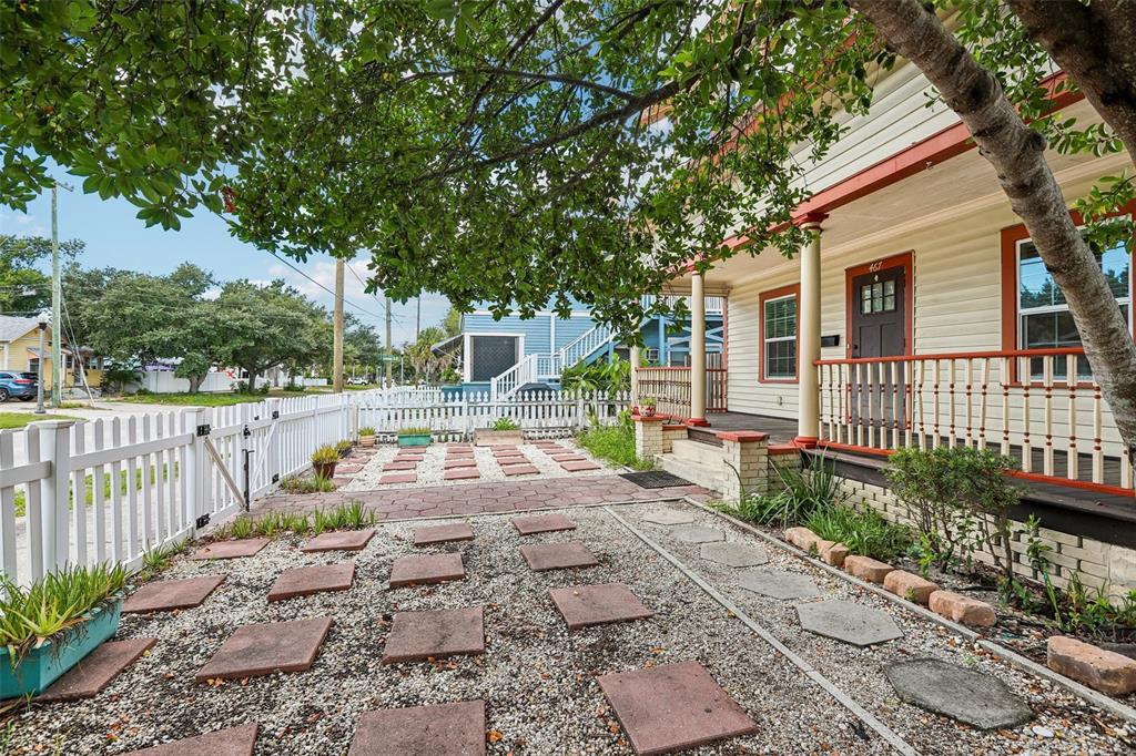 A house exterior features a front porch, a white picket fence, and a stone walkway — 467 9TH AVENUE N, ST PETERSBURG, FL