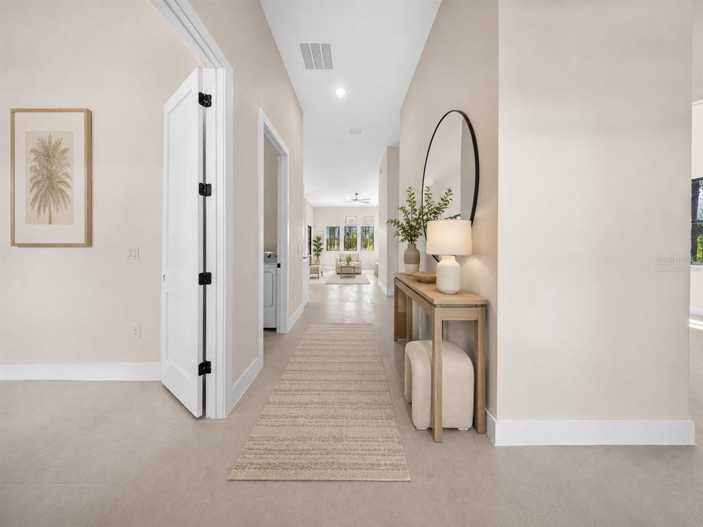 A hallway with light tile floors leads toward a living area with a console table — 372 MATSON LANE, PORT CHARLOTTE, FL