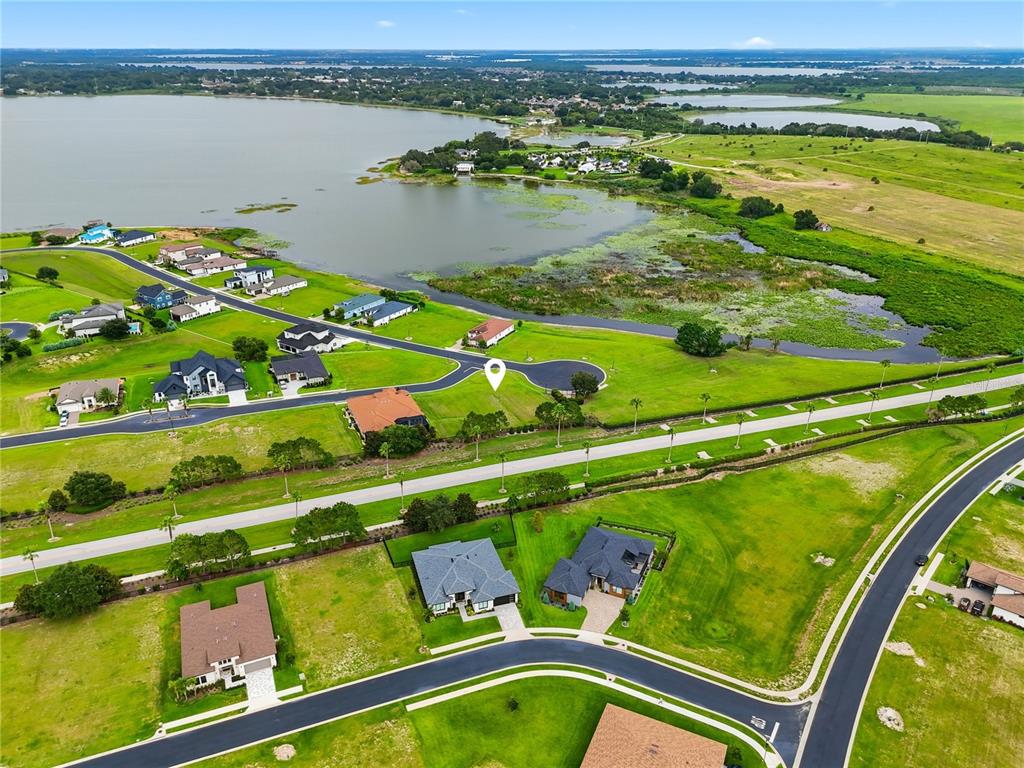 An aerial view shows a community clubhouse with two swimming pools and a tennis court — 103 BLAZING STAR AVENUE, LAKE ALFRED, FL
