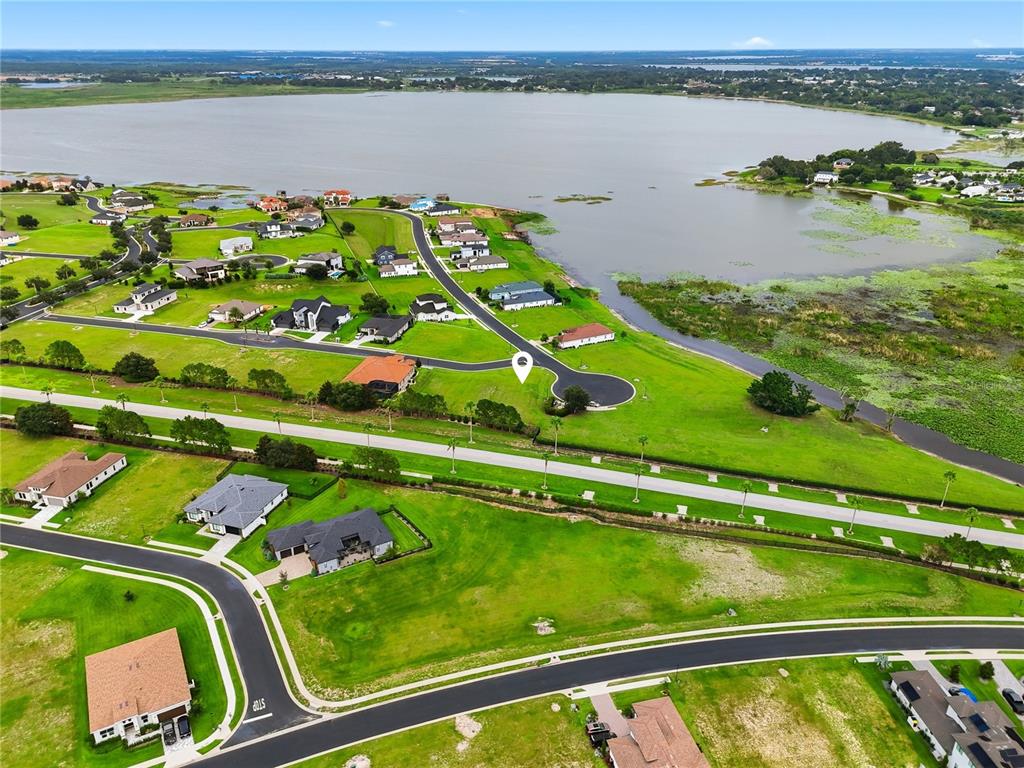 A large, single-story clubhouse building with a red tile roof and a parking lot — 103 BLAZING STAR AVENUE, LAKE ALFRED, FL