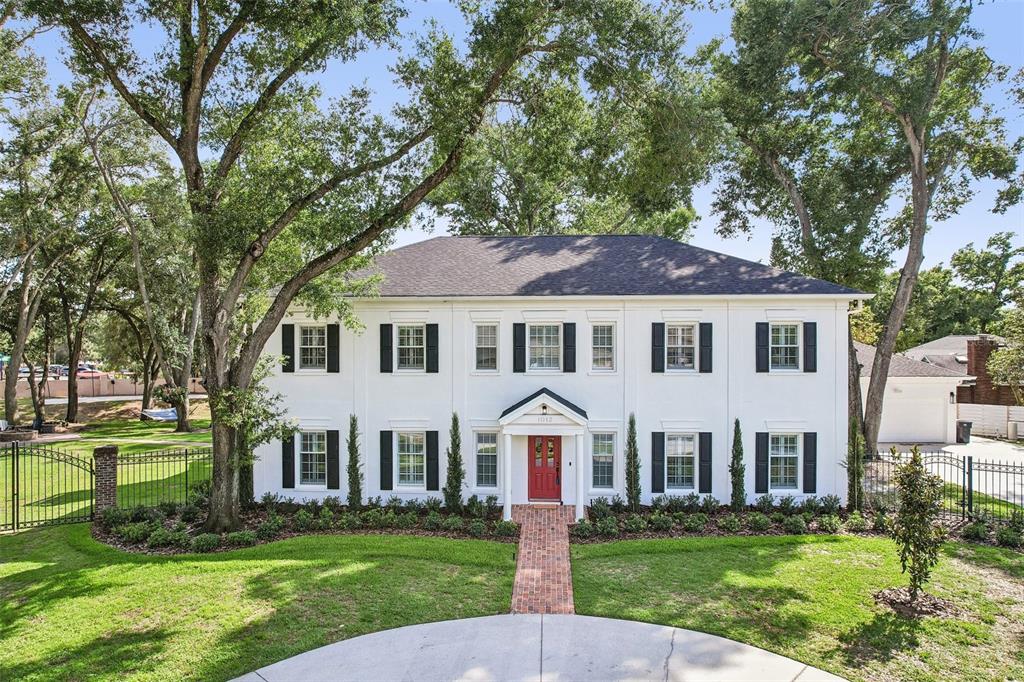 A two-story white colonial house with black shutters and a red front door — 1012 MORFIELD LANE, BRANDON, FL