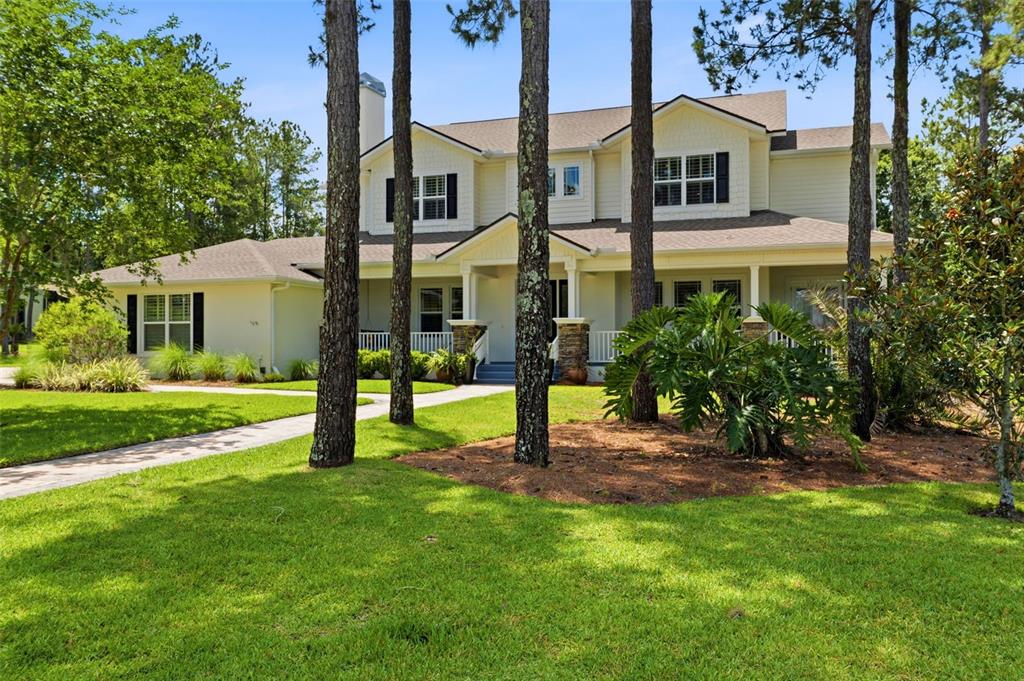 A two-story house with light siding, a covered front porch, and tall pine trees — 5251 SUMMIT VIEW DRIVE, BROOKSVILLE, FL