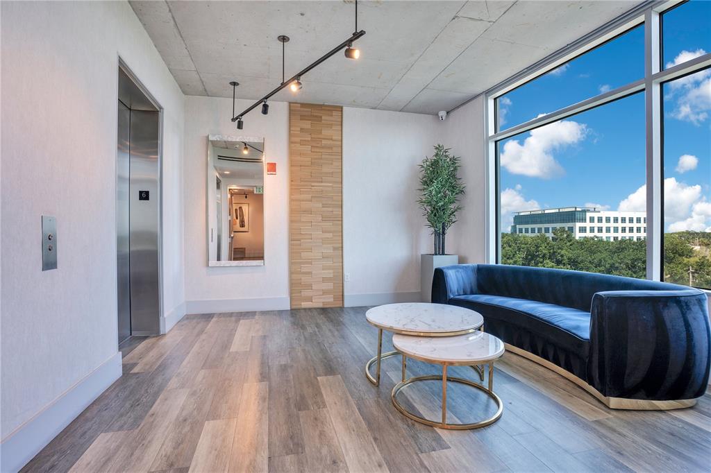 A modern lobby features a blue velvet sofa, marble nesting tables, and a large window — 525 E JACKSON STREET UNIT 509, ORLANDO, FL