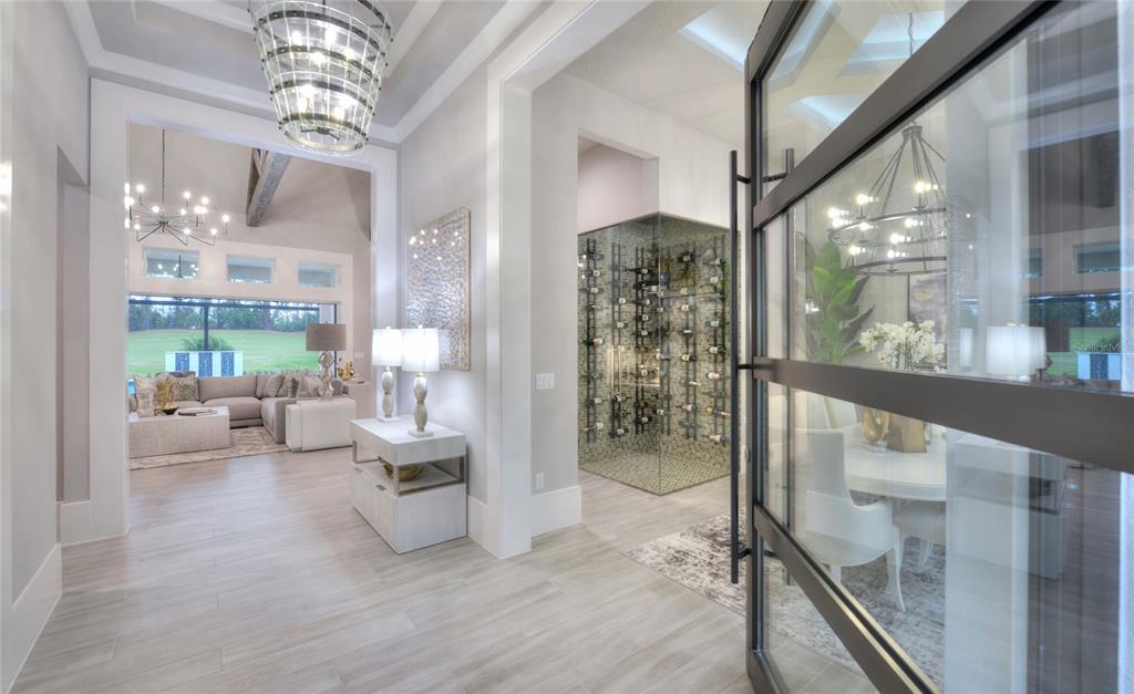 A bright foyer leads to a living area, a glass-enclosed wine cellar, and a dining room — 1009 SUDBURY LANE, ORMOND BEACH, FL