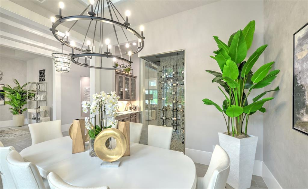 A dining room features a white table, modern chandelier, and a large potted plant — 1009 SUDBURY LANE, ORMOND BEACH, FL