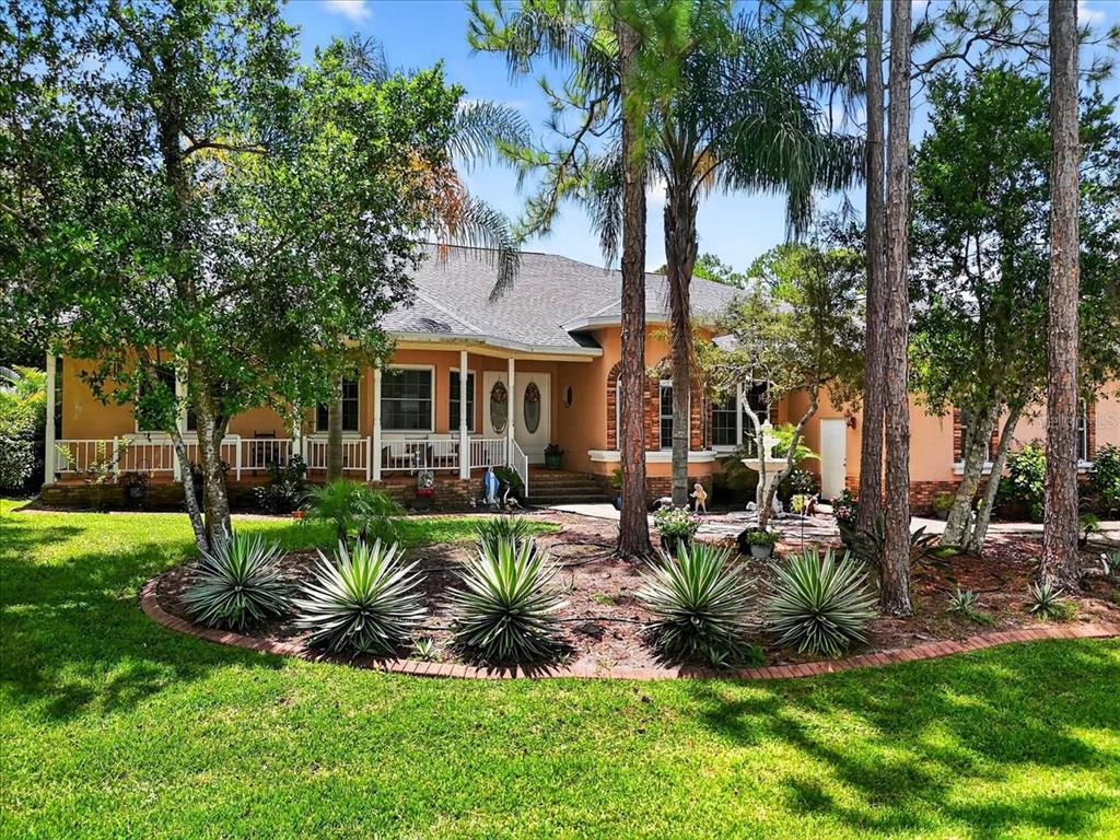 A single-story house with a peach-colored exterior, a front porch, and a landscaped front yard — 1727 STREAM AVENUE, SEBRING, FL