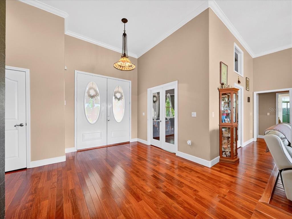 An entryway with hardwood floors, a hanging pendant light, and double front doors — 1727 STREAM AVENUE, SEBRING, FL