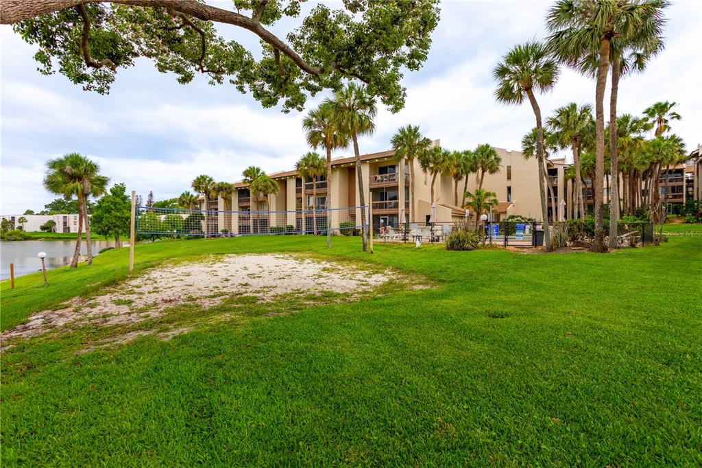 A volleyball court sits on a grassy lawn in front of a multi-story apartment building — 618 ORANGE DRIVE UNIT 216, ALTAMONTE SPRINGS, FL