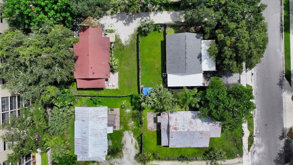 An aerial view shows four residential houses with surrounding trees, lawns, and paved driveways — 1569 7TH STREET, SARASOTA, FL