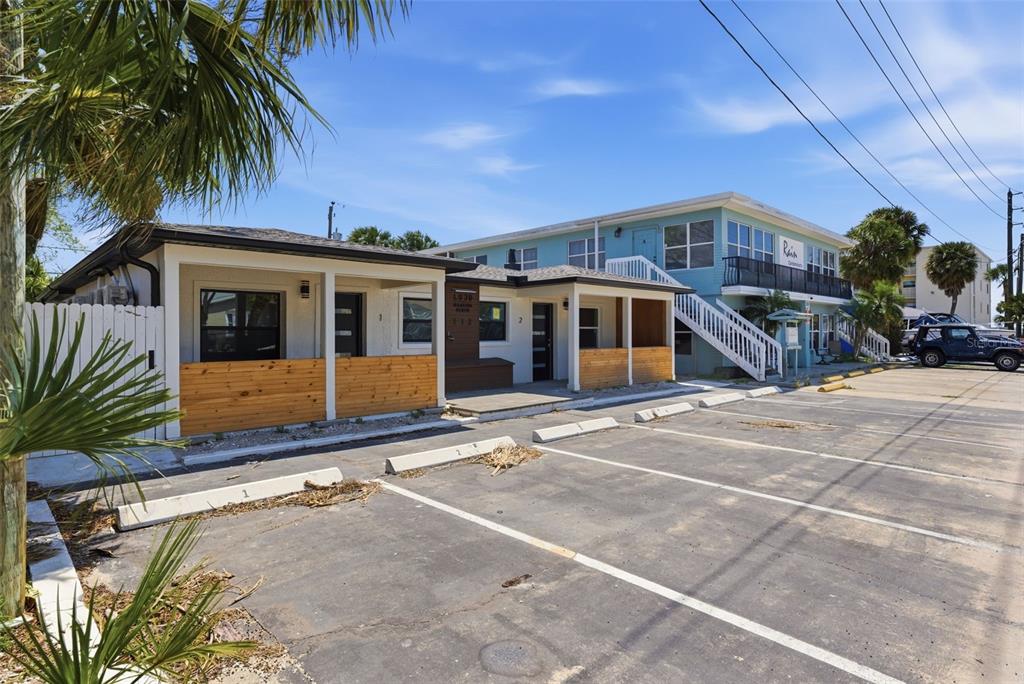 A single-story building with wooden accents sits next to a two-story blue apartment complex — 113 145TH AVENUE E UNIT 5, MADEIRA BEACH, FL