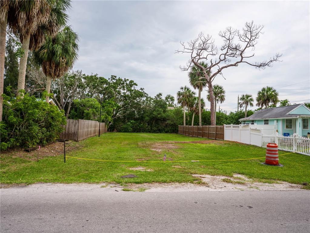 A vacant, grassy residential lot is bordered by wooden and white picket fences — 0 LIMESTONE, PORT RICHEY, FL