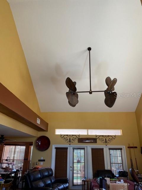 A living room features a vaulted ceiling, a unique dual-fan fixture, and glass patio doors — 936 ALLEGRO LANE, APOLLO BEACH, FL