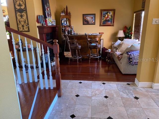 A living area features a home bar, a sofa, and a staircase with wooden treads — 936 ALLEGRO LANE, APOLLO BEACH, FL