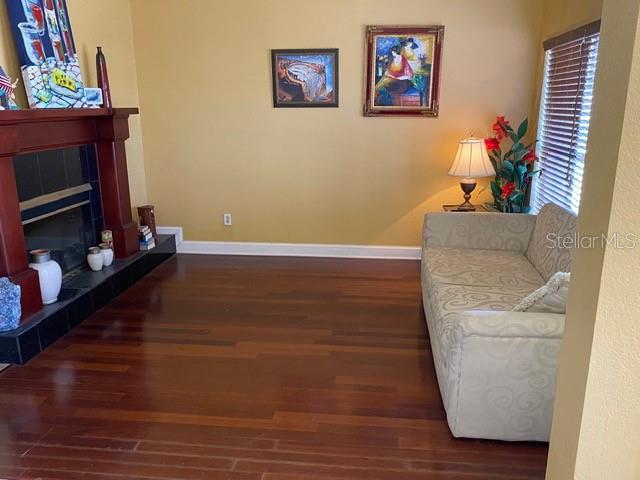 A living room features hardwood floors, a fireplace, a patterned sofa, and wall art — 936 ALLEGRO LANE, APOLLO BEACH, FL