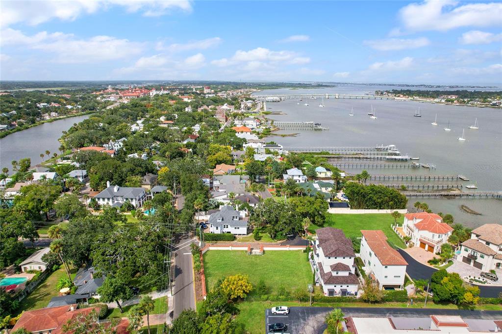 An aerial view shows a vacant grassy lot situated near a waterfront with docks — 1 SOUTH STREET UNIT A & B, ST AUGUSTINE, FL