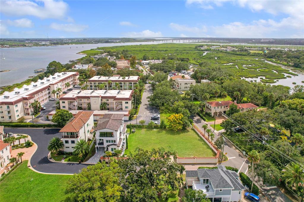 An aerial view shows a vacant grassy lot surrounded by residential buildings and coastal wetlands — 1 SOUTH STREET UNIT A & B, ST AUGUSTINE, FL