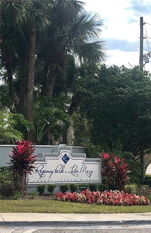 A sign for Regency Park at Lake Mary condominiums stands in a landscaped garden area — 717 SECRET HARBOR LANE UNIT 313, LAKE MARY, FL