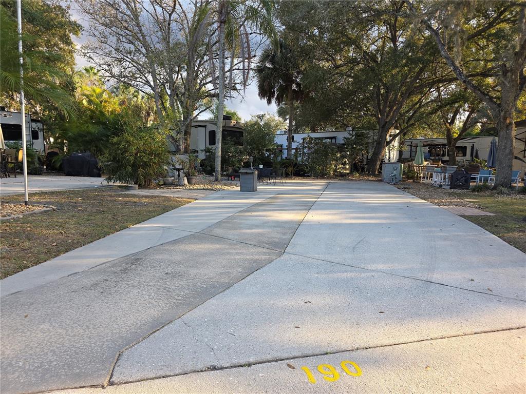 A concrete driveway at an RV park features the number 190 painted on the ground — 190 LONGHORN DRIVE, LAKE WALES, FL
