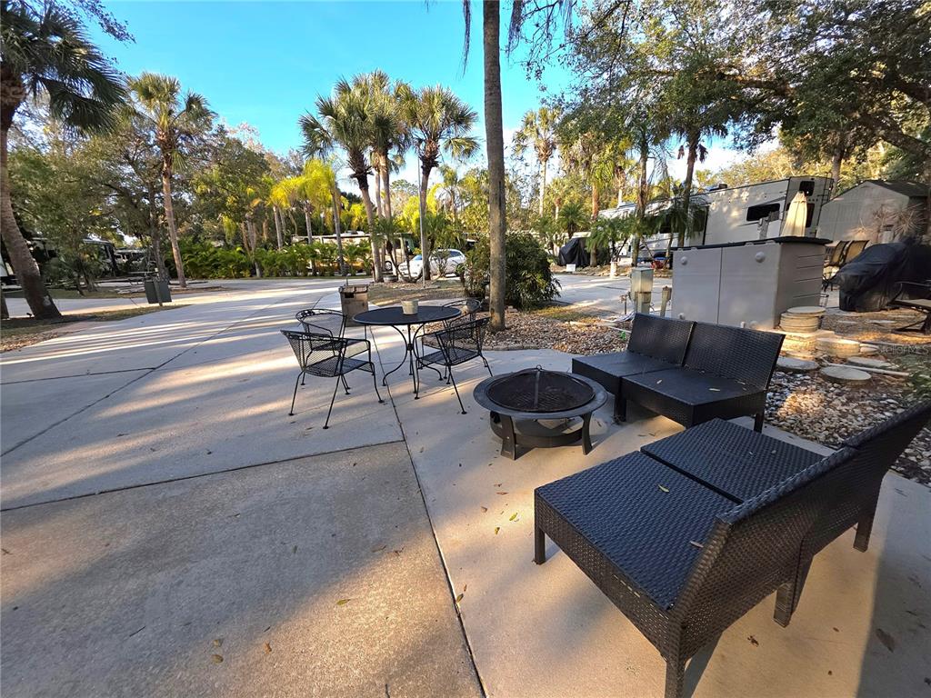 A concrete patio features a dining set, fire pit, and modular outdoor seating — 190 LONGHORN DRIVE, LAKE WALES, FL