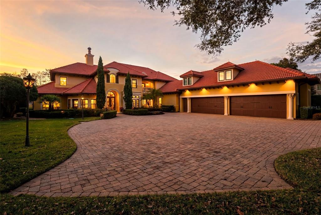 A large Mediterranean-style house with a red tile roof and a spacious brick paver driveway — 5070 DOWN POINT LANE, WINDERMERE, FL