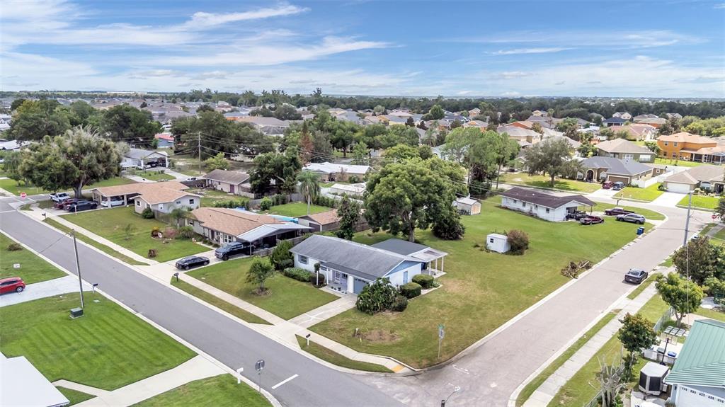 An aerial view shows a suburban neighborhood with single-story houses, green lawns, and paved streets — 265 E THELMA STREET, LAKE ALFRED, FL