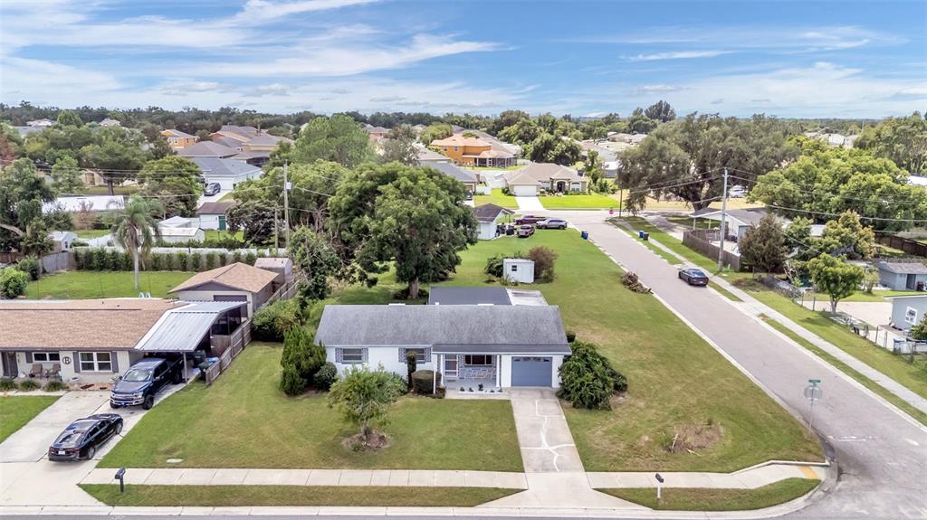 An aerial view shows a single-story house with a white exterior and a gray roof — 265 E THELMA STREET, LAKE ALFRED, FL