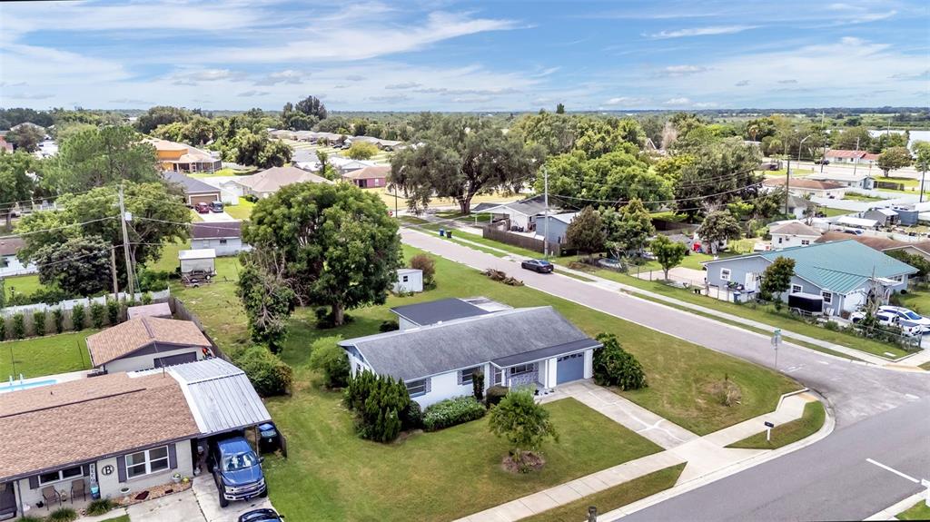 An aerial view shows a suburban neighborhood with houses, lawns, trees, and a paved street — 265 E THELMA STREET, LAKE ALFRED, FL