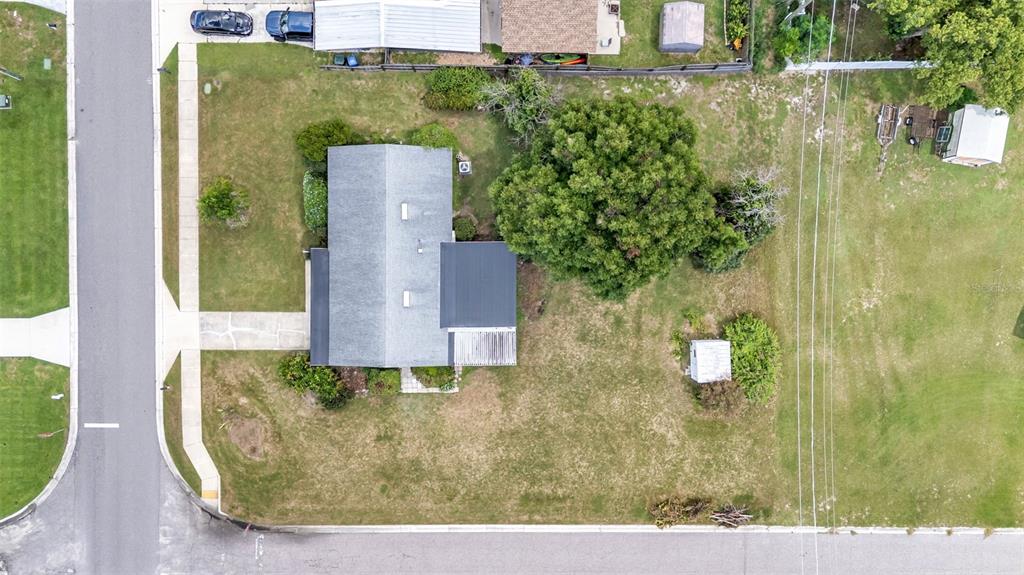 An aerial view shows a house with a gray roof, a large tree, and outbuildings — 265 E THELMA STREET, LAKE ALFRED, FL