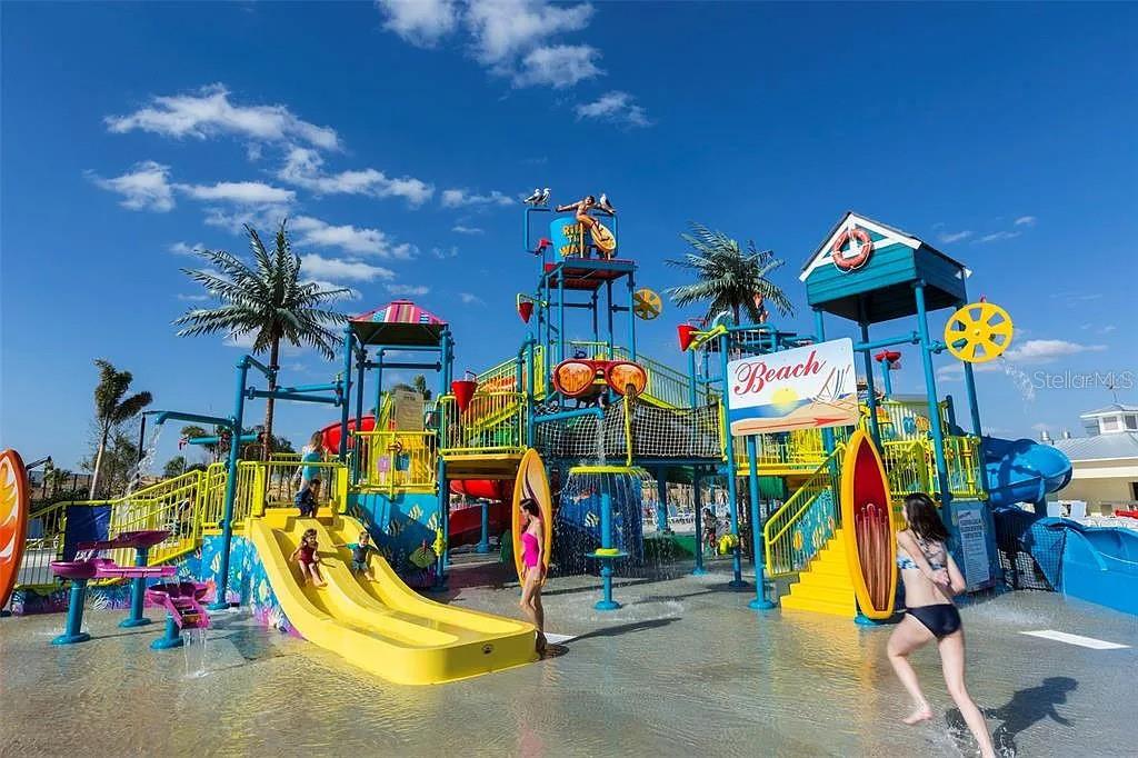 A colorful outdoor water park features multiple slides, climbing structures, and a large bucket dump — 310 PENDANT COURT, KISSIMMEE, FL