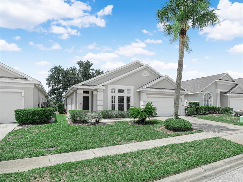 A single-story gray house with a palm tree and a manicured lawn in front — 16809 GLENBROOK BOULEVARD, CLERMONT, FL
