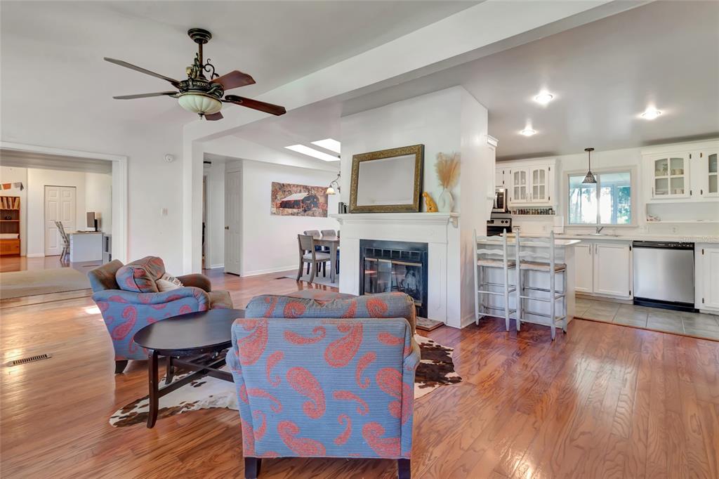 A living room features hardwood floors, a fireplace, two armchairs, and glass doors to a porch — 20361 1ST STREET, MC INTOSH, FL