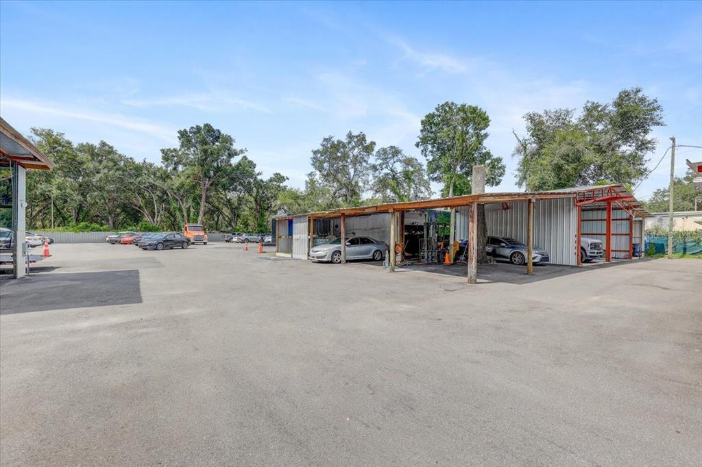 An outdoor parking lot features a covered metal structure with several parked vehicles — 11309 E 92 HIGHWAY, SEFFNER, FL
