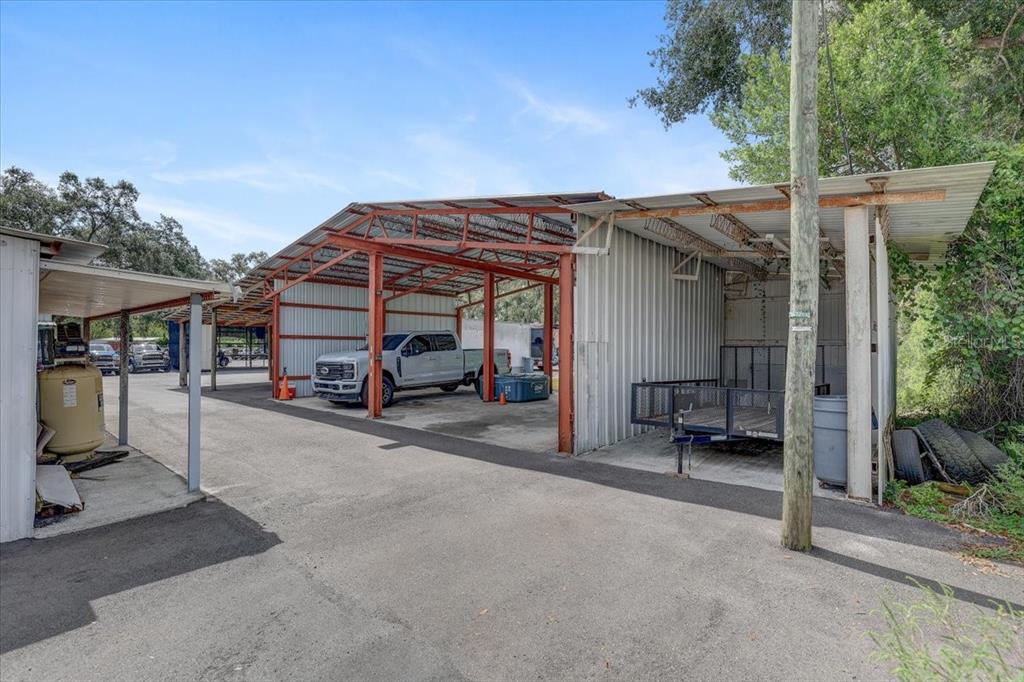 An outdoor covered parking structure with a white pickup truck and a utility trailer — 11309 E 92 HIGHWAY, SEFFNER, FL