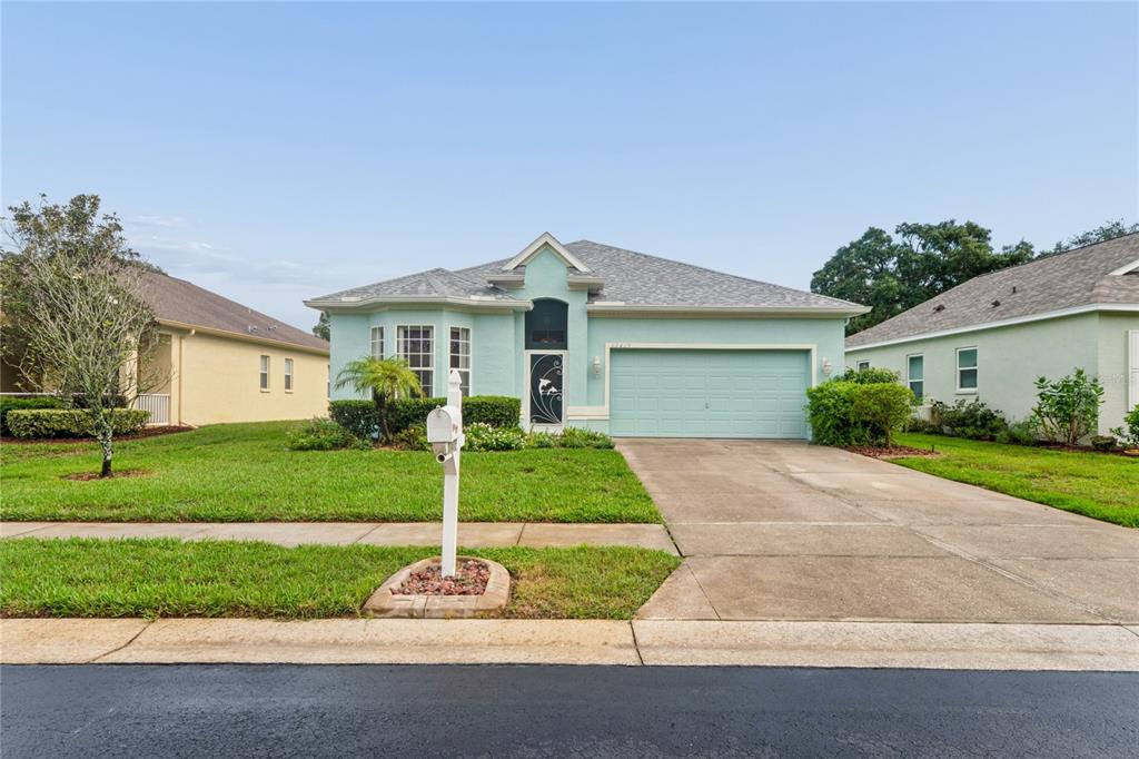 A light blue single-story house with a two-car garage and a front lawn — 11415 WINDSTAR COURT, NEW PORT RICHEY, FL