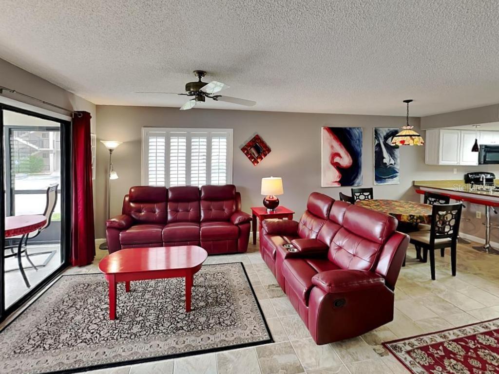 A living room features two red leather sofas, a red coffee table, and tile flooring — 4250 A1A S UNIT K12, ST AUGUSTINE, FL