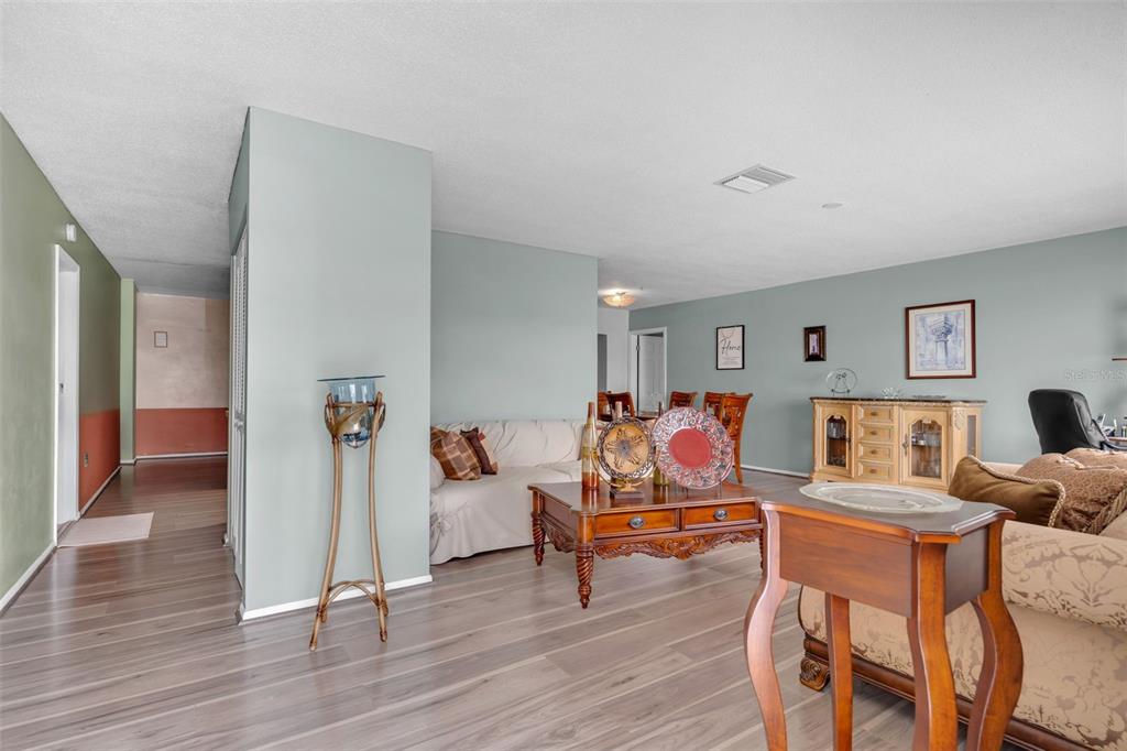 A living room with light blue walls, wood-look flooring, and traditional wooden furniture — 7500 NW 66TH TERRACE, TAMARAC, FL