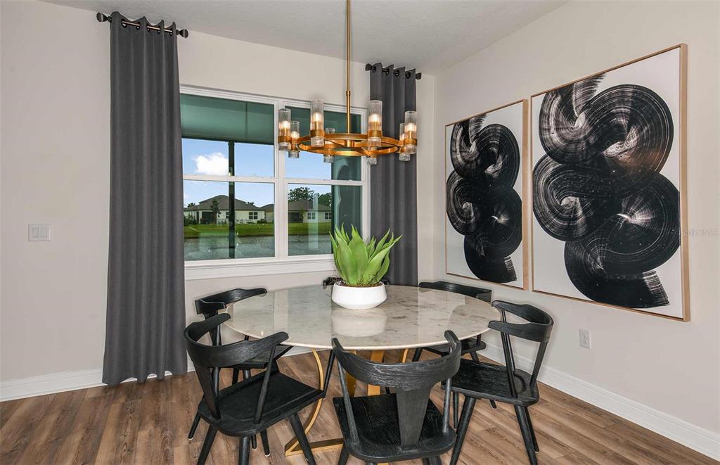 A dining room features a round marble table, black chairs, and a gold chandelier — 13585 CANYON RIDGE ROAD, SPRING HILL, FL