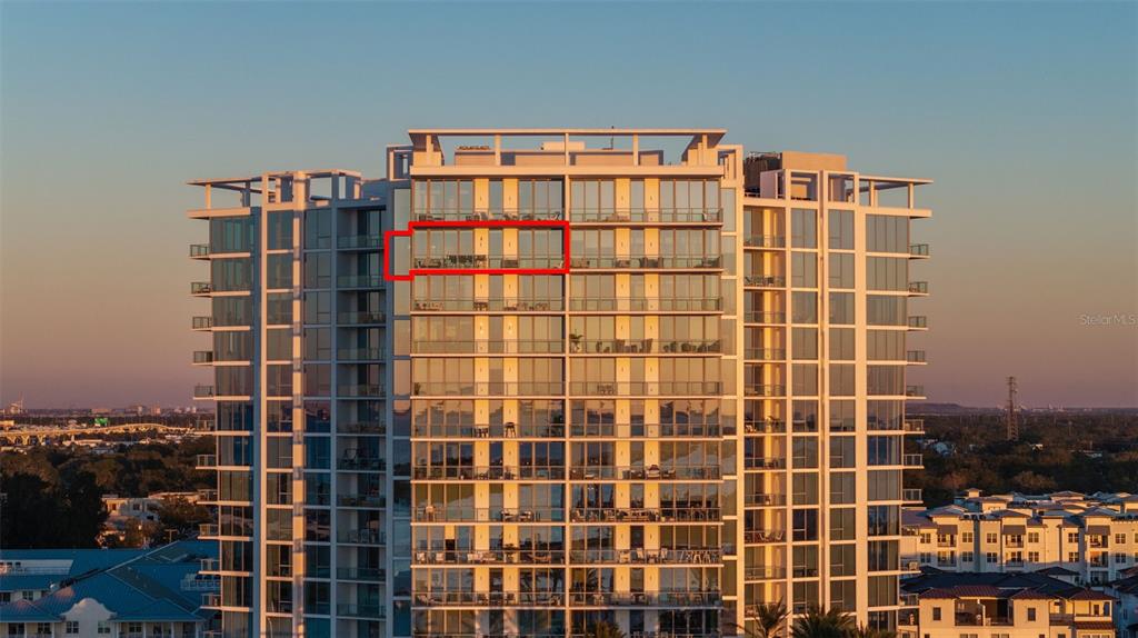An exterior view of a high-rise residential building with a red box highlighting a balcony — 5120 MARINA WAY UNIT 16002, TAMPA, FL